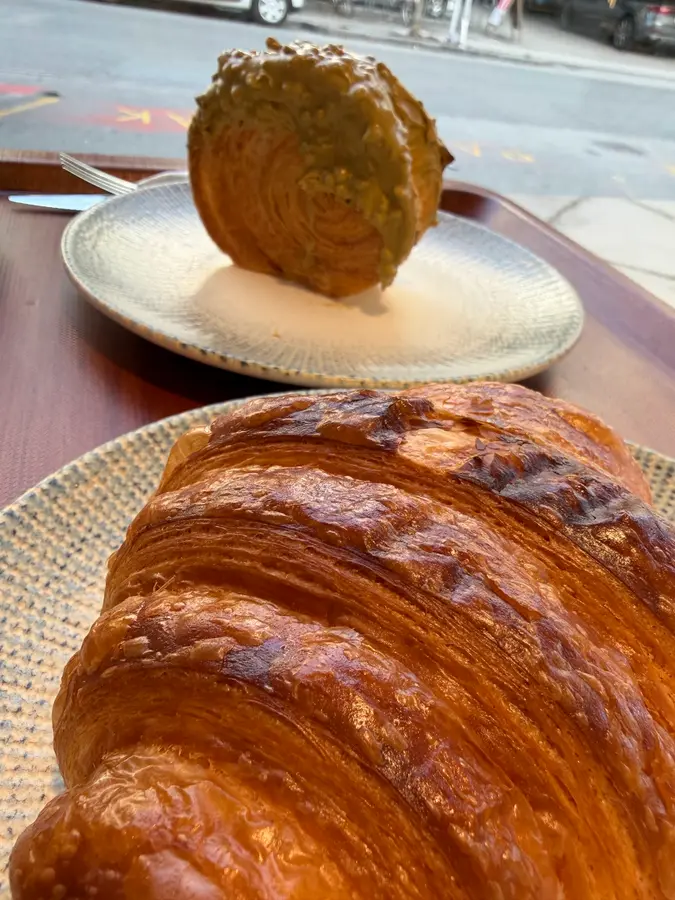 Croissant im Vordergrund, dahinter ein Croissant mit Pistazienglasur