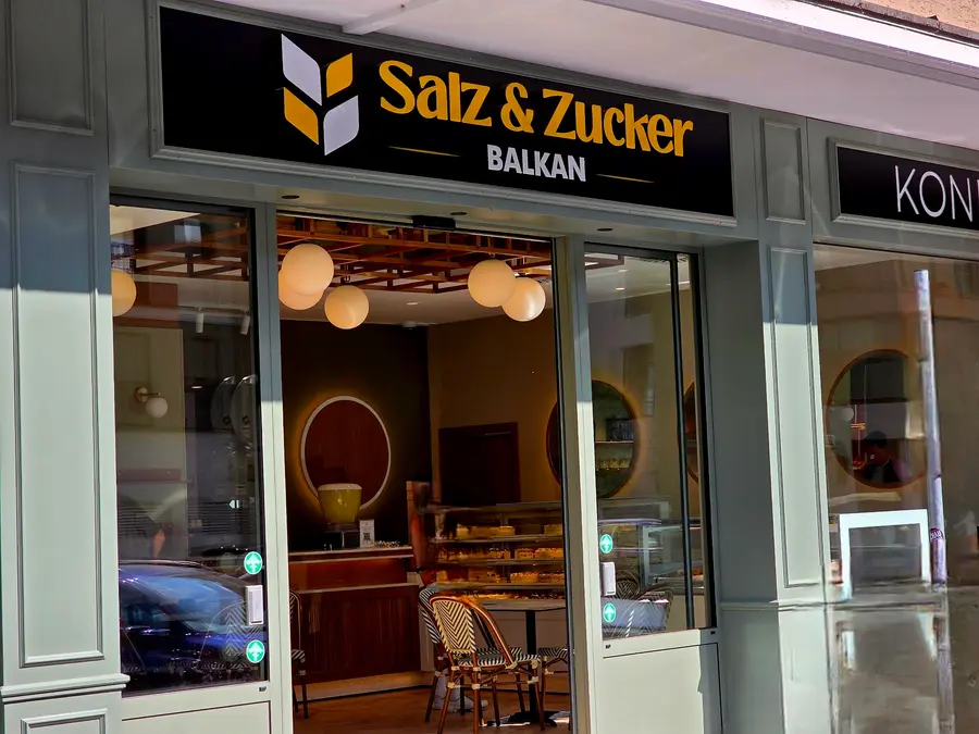 Das schwarze Schild mit goldenem Schriftzug Salz & Zucker Balkan über dem Eingang
